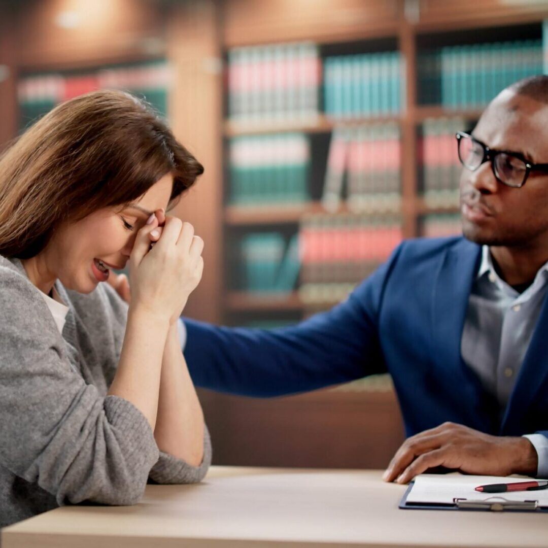 Woman comforted by man in office.
